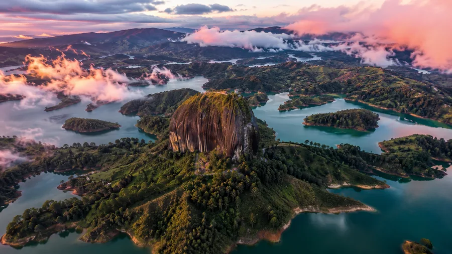Aerial view of El Peñol monolith rising from the emerald Guatapé reservoir at sunrise