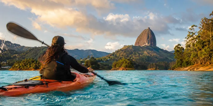 Kayaking on the Guatapé reservoir with El Peñol rock in the distance